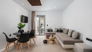 Un salon moderne comprenant un canapé, une table à manger, des chaises et un téléviseur.