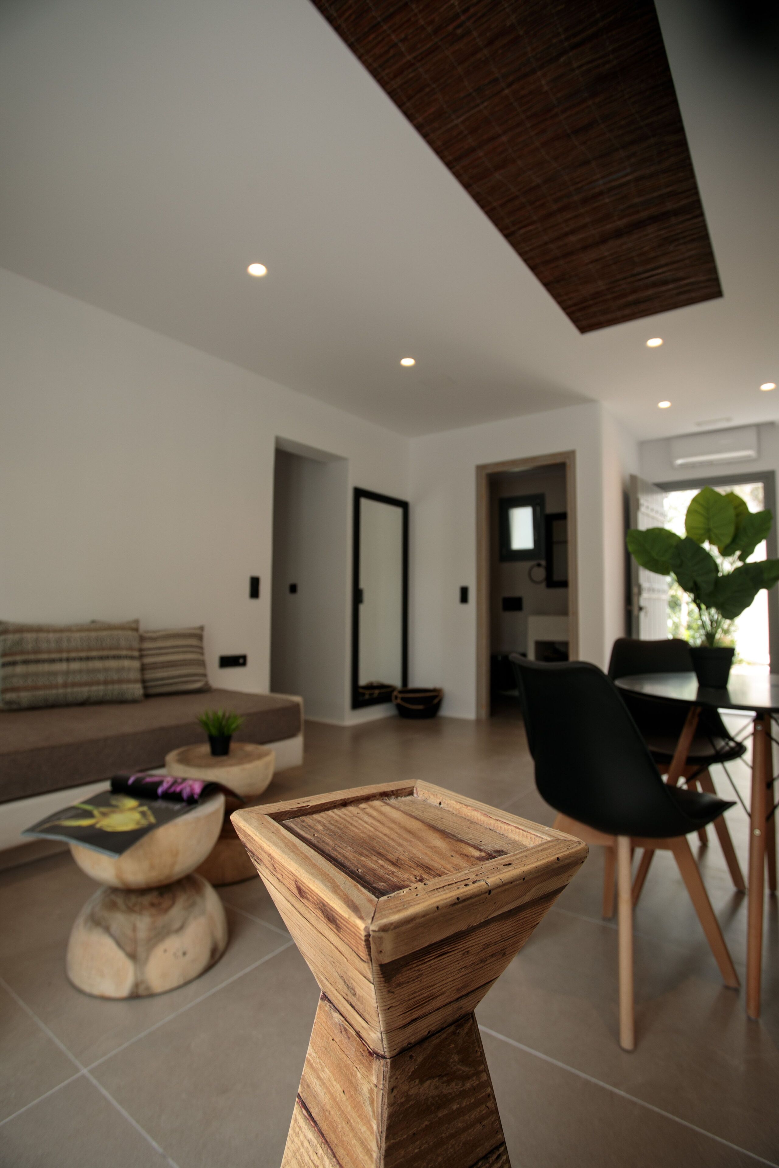 Una sala moderna con una mesa de centro de madera, un sofá y un comedor con sillas y una mesa.