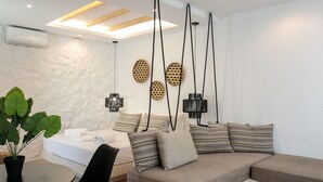 Un salon moderne avec un canapé d’angle, une table à manger avec des chaises et un luminaire suspendu.
