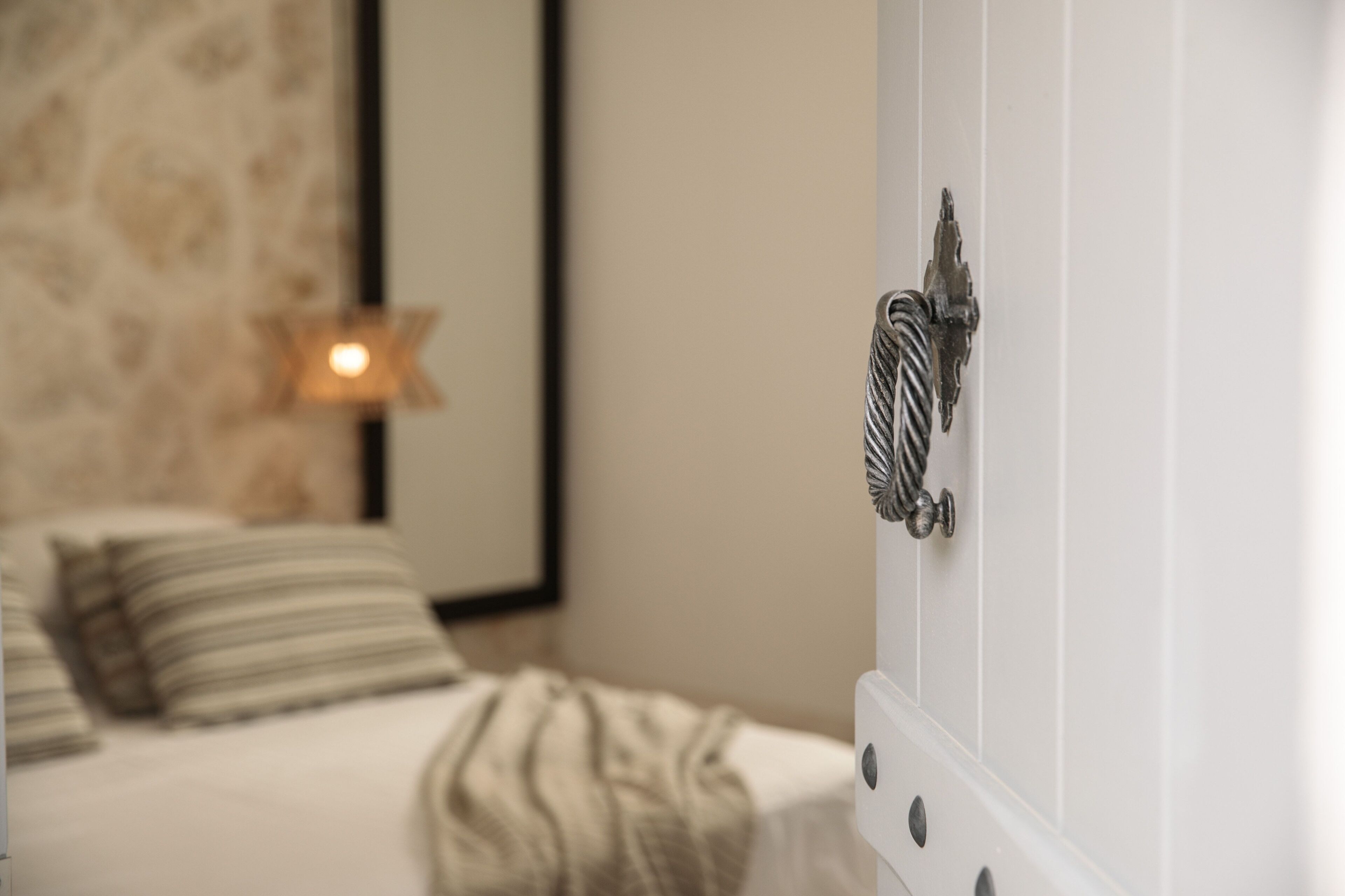 Une chambre à coucher avec un lit, une table de chevet et un luminaire fixé au mur.