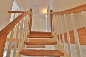 Un escalier en bois, avec des rampes blanches, mène à une porte portant l’inscription « Privé ».