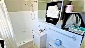 A bathroom with a shower, toilet, sink, and a mirror with a towel rack.
