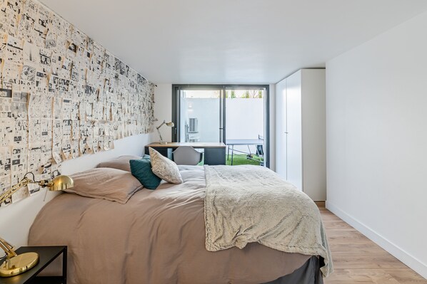 A bedroom with a large bed, a desk, and a balcony with a view. - Villa Design D'architecte - 10 Personnes - Jacuzzi, Piscine ,tennis (Cassis)