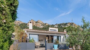 A modern house with a patio, large windows, and a mountain backdrop. - Villa Design D'architecte - 10 Personnes - Jacuzzi, Piscine ,tennis (Cassis)