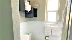 A bathroom with a toilet, sink, and towel rack. - Zesty Queen Deluxe (Daytona Beach)