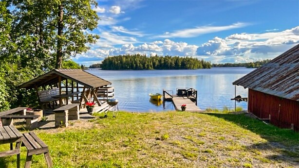 A lakeside cabin with a dock, picnic tables, and a red building. - Nice home in Rörvik with WiFi (Rörvik)