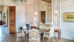 A formal room with ornate furniture, a chandelier, and a framed certificate on the wall. - 1 bedroom stunning apartment in Ocquerre (Ocquerre)
