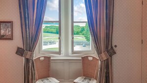 A room with two wicker chairs facing a window with blue curtains. - 1 bedroom stunning apartment in Ocquerre (Ocquerre)