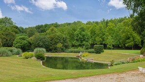 A serene garden with a pond, surrounded by lush greenery and a clear sky. - 1 bedroom stunning apartment in Ocquerre (Ocquerre)