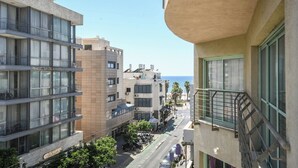 A multi-story building with balconies, a street in front, and a clear view of the sea. - Mamad Modern 1BR w/ Style, City Views & Beach (Tel Aviv-Yafo)