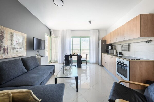 A modern apartment with a living room, dining area, and kitchen. - Mamad Elegant Sea-View Apt w Mamad by Sea N' Rent (Tel Aviv-Yafo)