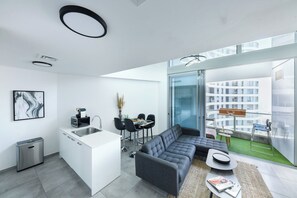A modern apartment with a kitchen, dining area, and a living room with a large window.