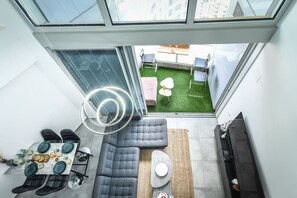 Un intérieur moderne comprenant un coin repas, un canapé et une vue sur un jardin sur le toit.