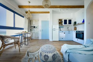 Un vaste espace de vie comprenant une cuisine, un plancher en bois et une grande fenêtre.