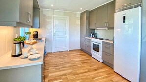 A modern kitchen with a central island, built-in oven, and a refrigerator. - Amazing home in Lunde with WiFi (Lunde)