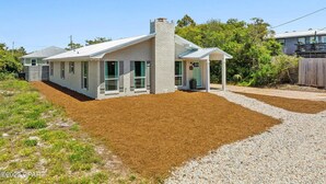 A single-story house with a covered porch, a chimney, and a number 55 sign. - Relaxed Beach Cottage, Steps to Sand, Near 30A & Pier Park (Panama City Beach)