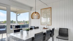 A dining area with a large table, chairs, a pendant light, and a framed map on the wall. - 3 bedroom awesome home in Hejls (Hejls)