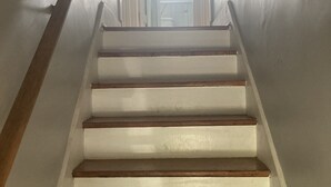 Un escalier avec des marches en bois et des murs blancs.
