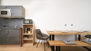 Een moderne keuken met een magnetron, een toasteroven en een houten plankensysteem.