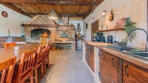 Une cuisine rustique avec un four en briques, des meubles en bois et des murs en pierre.
