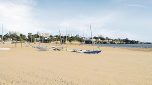 Una playa arenosa con varios veleros amarrados.