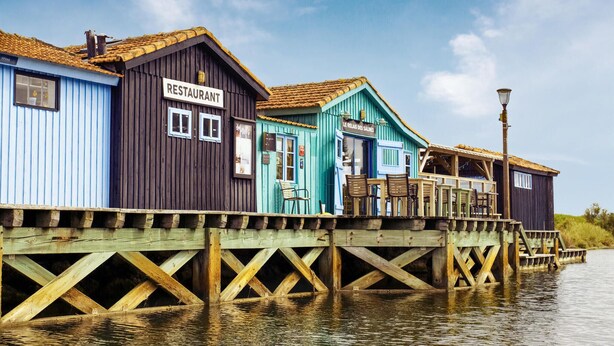 Un muelle de madera con un restaurante y una cafetería.