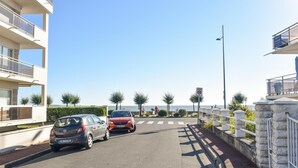 Una carretera costera con autos, un paso de peatones y una señal de límite de velocidad.