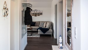 Ein modernes Wohnzimmer mit einer Couch, einem Couchtisch und einem kleinen Tisch mit einer Dekoration.