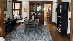 A dining area with a table, chairs, a ceiling fan, and a bookshelf. - Stylish, Inviting 2-BR near Logan Square and Wrigley Field (Chicago)