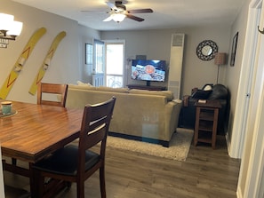 A living room with a wooden dining table, chairs, a sofa, and a television. - Cozy modern 4 bedroom, 10 min walk to beach & sunset (Roscommon)