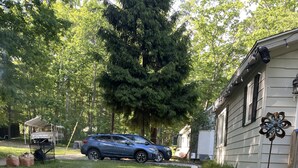 A backyard with a fire pit, a blue car, and a house. - Cozy modern 4 bedroom, 10 min walk to beach & sunset (Roscommon)