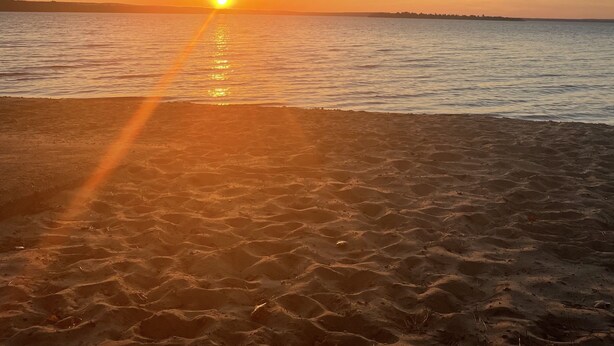 A beach at sunset with the sun setting over the horizon. - Cozy modern 4 bedroom, 10 min walk to beach & sunset (Roscommon)