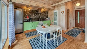 A cozy kitchen with a stone backsplash, green cabinets, and a dining area with a round table and chairs. - Awesome apartment in Färgelanda (Färgelanda)
