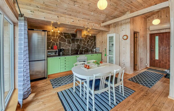 A cozy kitchen with a stone backsplash, green cabinets, and a dining area with a round table and chairs. - Awesome apartment in Färgelanda (Färgelanda)