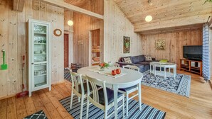 A wooden interior with a dining area, sofa, TV, and a clock on the wall. - Awesome apartment in Färgelanda (Färgelanda)