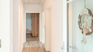 A hallway with wooden flooring, white walls, and a door leading to a room. - 2 bedroom beautiful home in Stapel (Stapel)