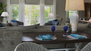 A modern living room with a sofa set, a dining table with placemats, and a large lamp. - Luxury Island Escape @ Palm Tree Villa: Private Rooftop Deck & Saltwater Pool (Bookelia)
