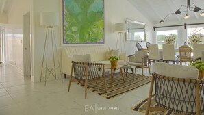 A spacious living room with a high ceiling, a large abstract painting, and a dining area with modern furniture. - Fantastic Golf-View Villa. W/ Jacuzzi, Maid (CASA DE CAMPO)