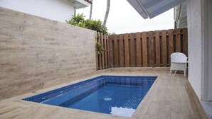 A rectangular swimming pool with blue tiles, surrounded by a wooden deck and a wooden fence. - Fantastic Golf-View Villa. W/ Jacuzzi, Maid (CASA DE CAMPO)