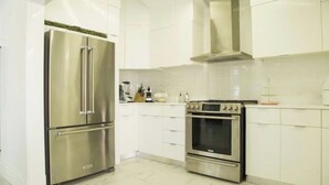 A modern kitchen with stainless steel appliances, white cabinetry, and a tiled backsplash. - Fantastic Golf-View Villa. W/ Jacuzzi, Maid (CASA DE CAMPO)