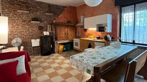 Eine kleine Küche mit Backsteinwand, Holzschränken und einem Schachbrettboden.