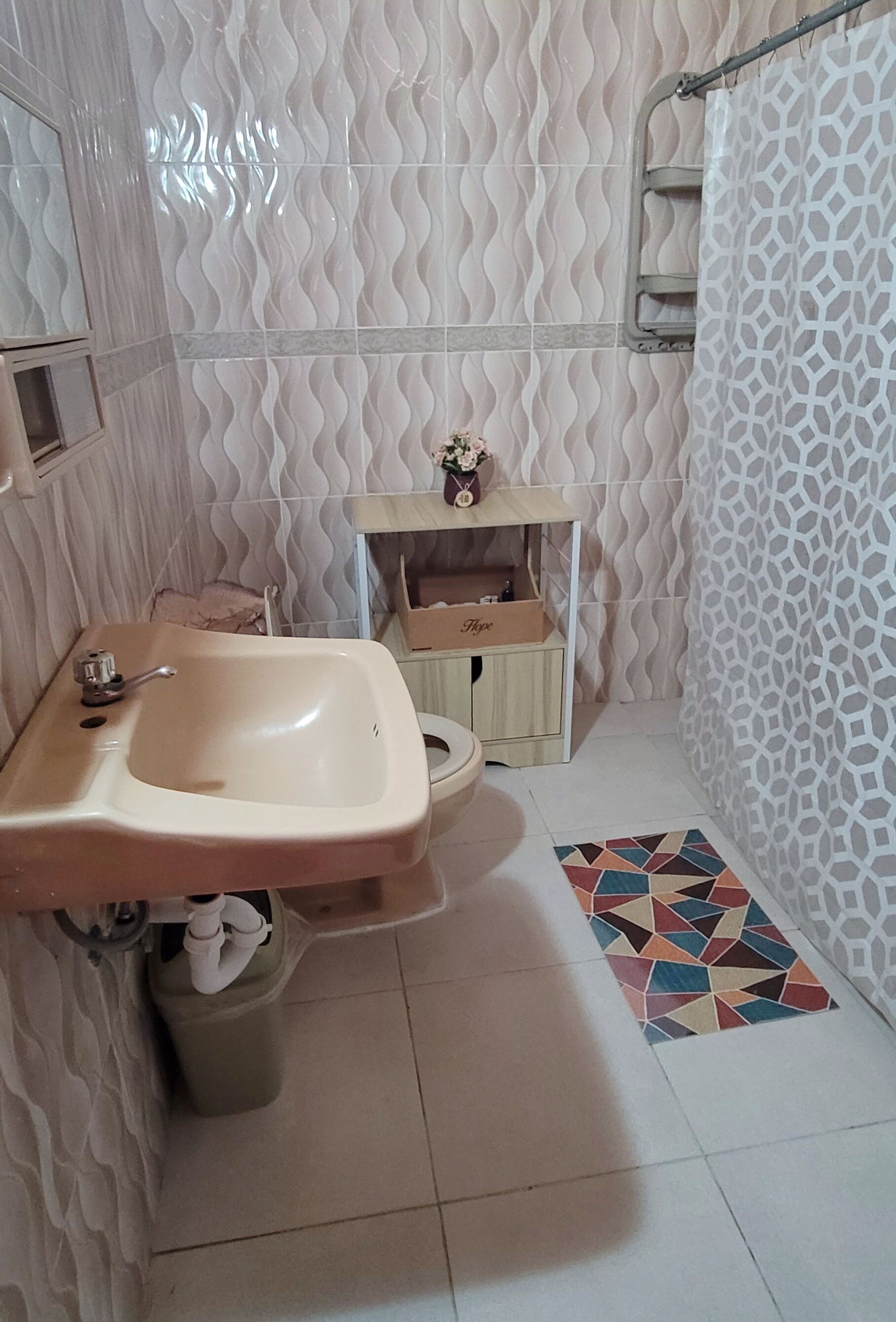 Un bagno con lavandino, wc e zona doccia.