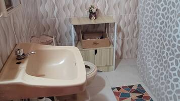 Un bagno con lavandino, wc e zona doccia.