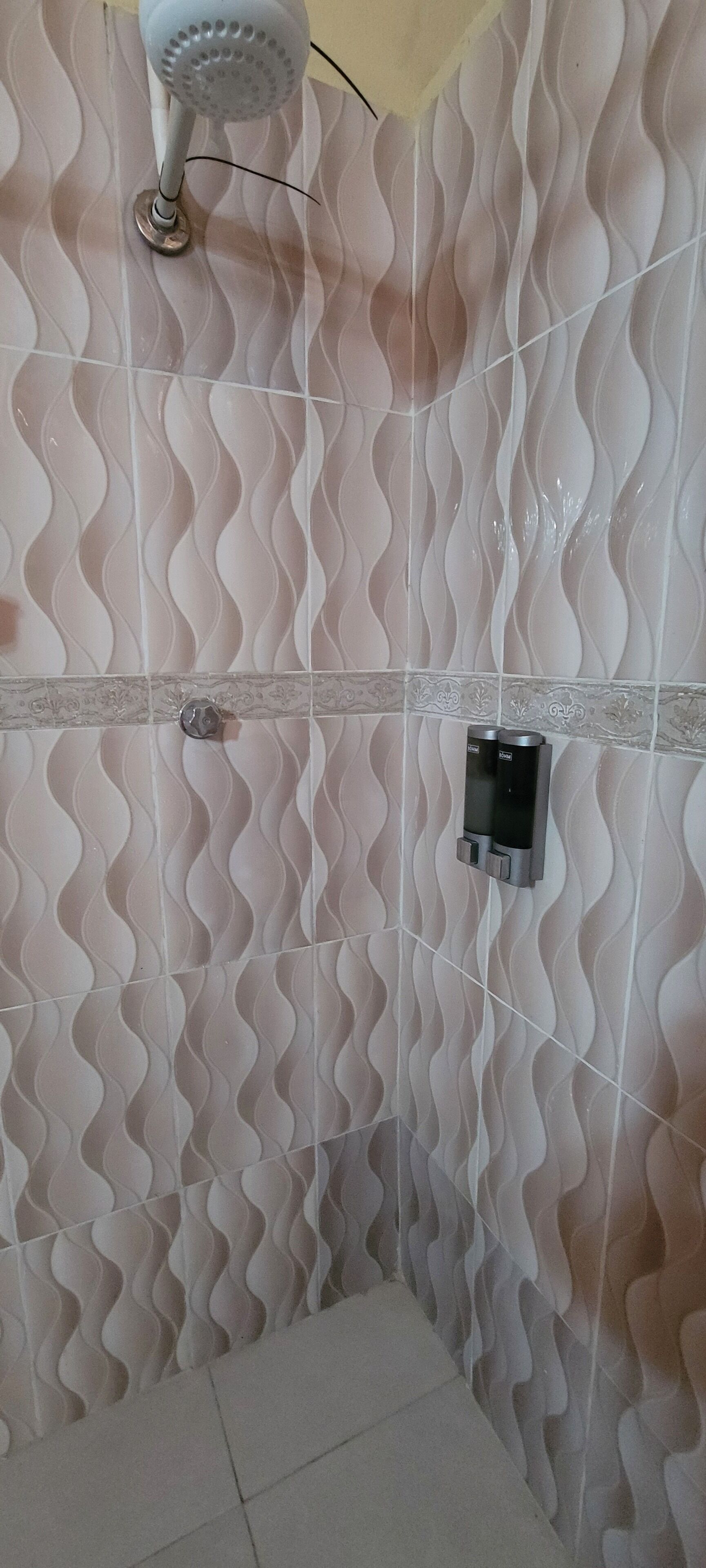 Een douche, handdoeken, zeep, toiletpapier