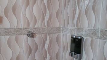 Een douche, handdoeken, zeep, toiletpapier