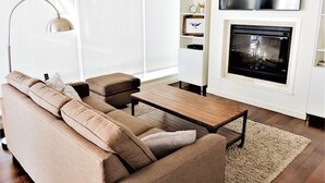 A modern living room with a sofa, coffee table, and fireplace.
