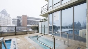 A rooftop pool area with a view of surrounding buildings, including a notable tower.