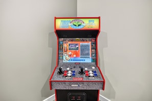 A retro arcade machine with a screen displaying a fighting game, featuring a joystick and multiple buttons.