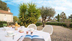 An outdoor dining table set with a book, bowls, and condiments. - Cosy apartment for 4 guests with WIFI, TV and patio (Fréjus)