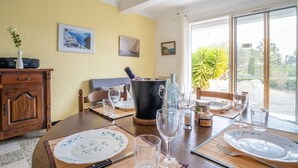 A dining area with a table set for two, a large black pot, and a view of the outdoors. - Cosy apartment for 4 guests with WIFI, TV and patio (Fréjus)